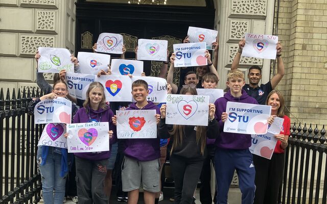 Young people holding posters supporting Stu