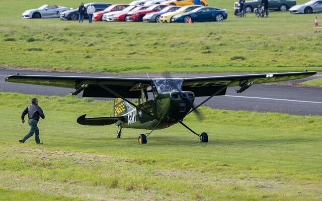 small aircraft and classic cars in background