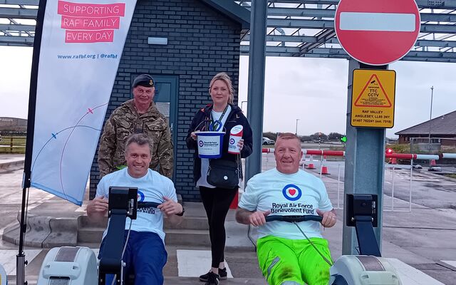 2 personnel on rowing machines with Fund flag