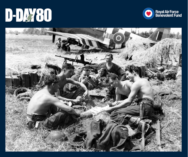 Leading Aircraftman George Langley, a servicing commando from Tewkesbury takes a break while armourers fit a 500lb bomb beneath the wing of a Mustang III of 122 Squadron at B7/Martragny, Normandy, on 25 June 1944.
