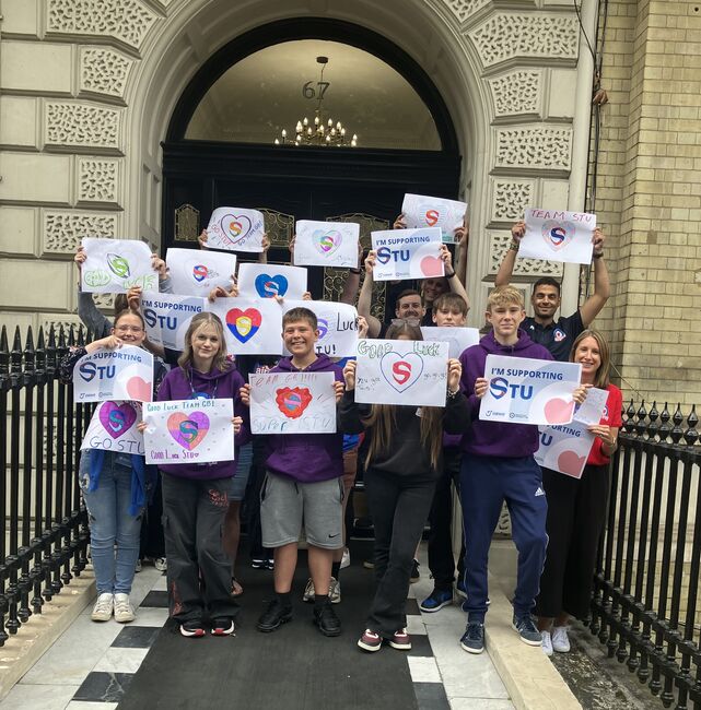 Young people holding posters supporting Stu