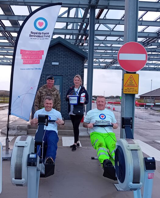 2 personnel on rowing machines with Fund flag